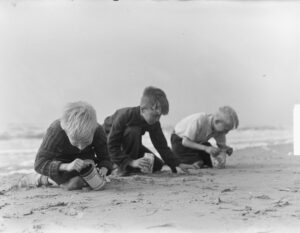 kinderen rapen coloradokevers op het strand